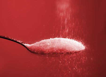 sugar on spoon, pouring sweet white food ingredient onto silverware utensilの写真素材