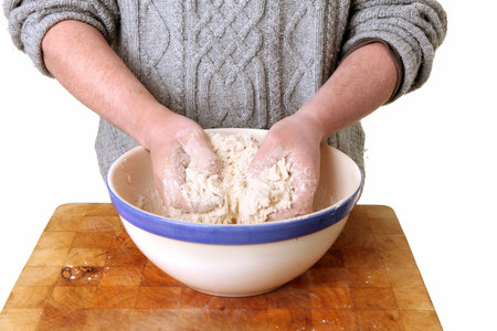 making bread, kneading dough with hands and white flour. cooking homemade basic food, pizza or cake