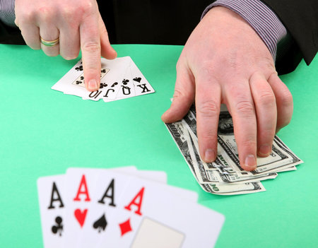 game of cards or poker. gambling and winning money or losing. hand with four aces and stak of dollar...