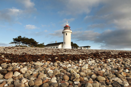 lighthouse on beach in denmark. navigation tower in white standing on coastの写真素材
