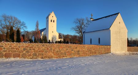 Church in denmark. white scandinavian place of christian worship with snow in the winterの写真素材