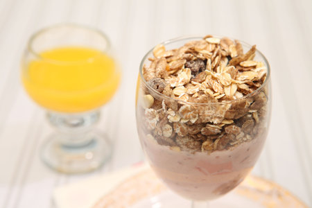 Healthy breakfast meal of yoghurt and muesli. Snack diet  meal of raisins, nuts and oats with dairy...