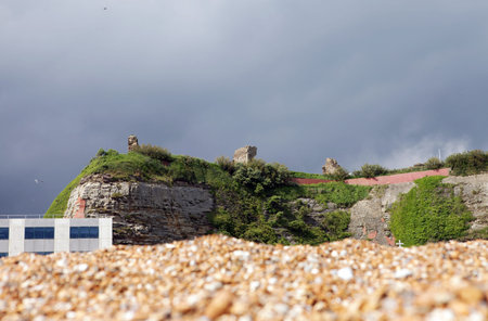 Hastings in England with pebble beach and architecture. The town castle ruins on top of cliff the...