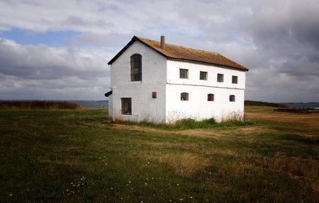 Farm house in Denmark. Home in the countryside isolated from other buildings on agriculture land or fieldの写真素材