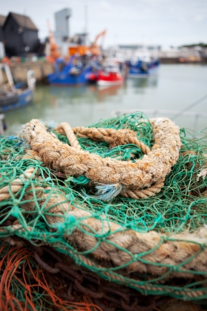 whitstable bay and fishing harbour. nets and rope with trawlers in backgroundの写真素材
