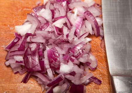 red onion on chopping board made of wood. cooking a meal preparing ingredientsの写真素材