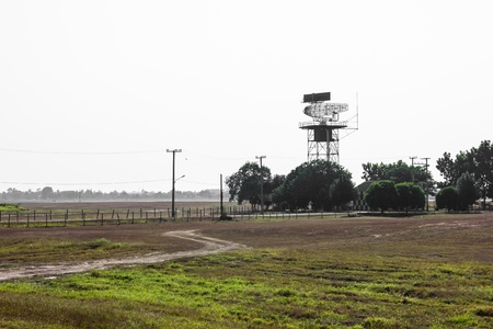 Red and white metal radar tower in airport area with plane landingの写真素材
