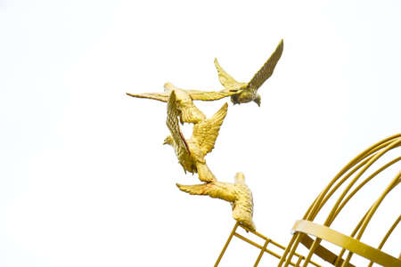 Gold Sculpture of a Dove Being Set Freeの写真素材