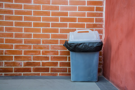 Black garbage bags and dirty white binの写真素材
