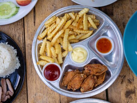 The fried chicken drumstick and french fries on wooden background.の写真素材