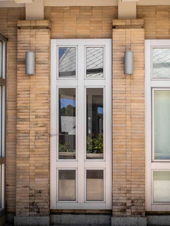 Glass windows and doors with turquoise frames at red brickedの写真素材