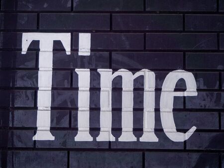 Black Brick Wall with Word Time in Worn White Paintの写真素材