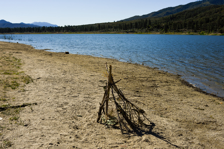 Setting up for tepee fire stand on lakeside beachの写真素材
