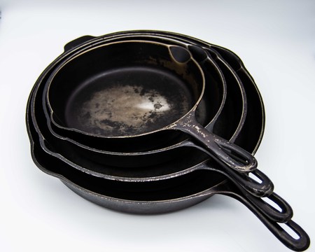 Used stack of cast iron skilletsの写真素材