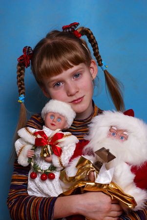 Portrait of the girl on a dark blue background with Christmas toys in handsの写真素材