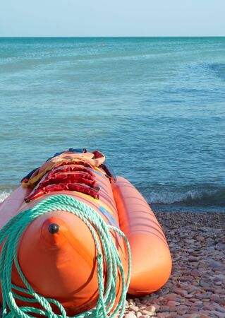 The boat for sea entertainments lays on sea coast covered with a pebble  の写真素材