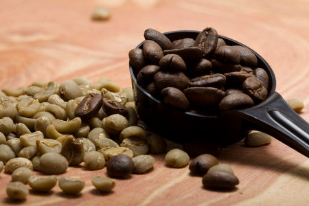 Scoop of roasted coffee with green coffee beansの写真素材