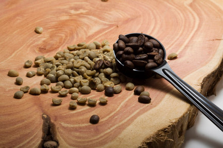 Scoop of roasted coffee with green coffee beansの写真素材
