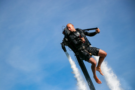 Thrillseeker, athlete strapped to Jet Lev, levitation soars into a blue sky with whispy cloudsの写真素材