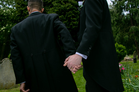 Gay wedding, grooms, husbands holding hands with wedding ring on showの写真素材