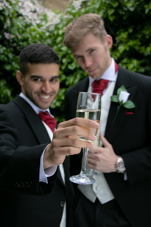 Gay couple at wedding reception toast being marriedの写真素材
