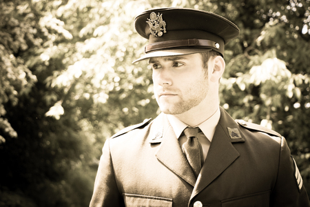 Handsome American WWII GI Army officer in uniform walking through woodsの写真素材