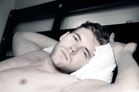Handsome, sexy good looking man with green eyes first thing in the morning, looking at camera in a...