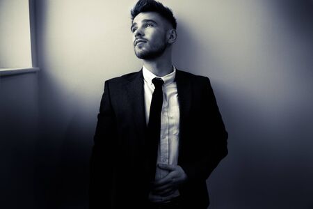 Handsome man wearing tie and jacket climbing stairsの写真素材