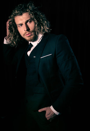 Low key lighting portrait of executive man with long hair in a suitの写真素材