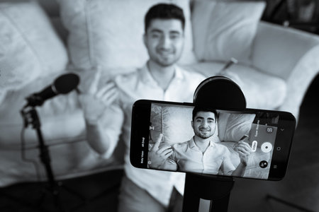 Young man recording video broadcast from home studio