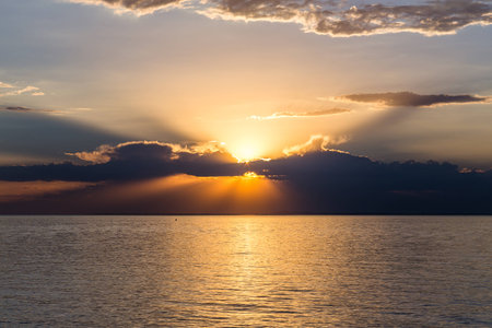 Sunset over the ocean with cloudsの写真素材