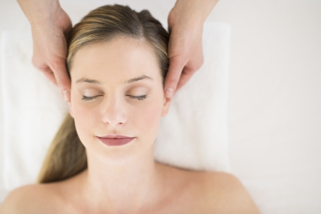 Directly above shot of attractive young woman receiving head massage at health spaの写真素材