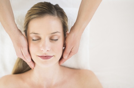 Directly above shot of relaxed young woman receiving head massage in health spaの写真素材