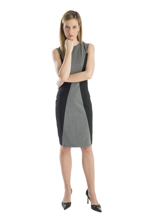 Full length of confident businesswoman with hand on chin standing against white backgroundの写真素材
