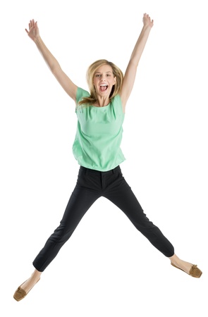 Full length portrait of excited young woman with arms raised in mid-air isolated against white backgroundの写真素材