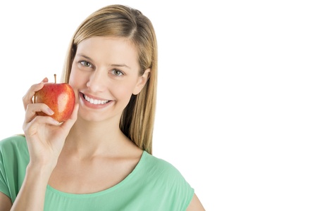 Portrait of happy young woman holding fresh apple isolated over white backgroundの写真素材