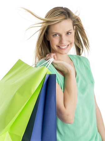 Portrait of beautiful young woman carrying shopping bags isolated over white backgroundの写真素材