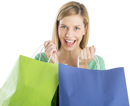 Portrait of happy young woman holding shopping bags against white backgroundの写真素材