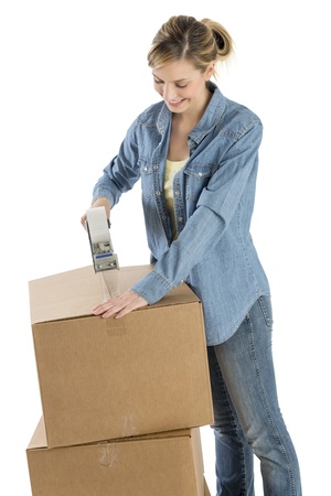 Beautiful young woman taping cardboard boxes isolated over white backgroundの写真素材