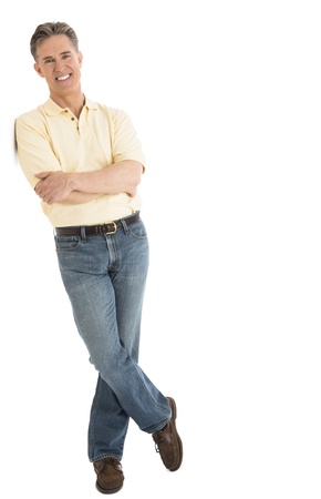 Full length portrait of happy mature man in casuals standing arms crossed over white backgroundの写真素材