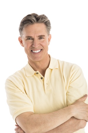 Portrait of happy mature man standing arms crossed over white backgroundの写真素材