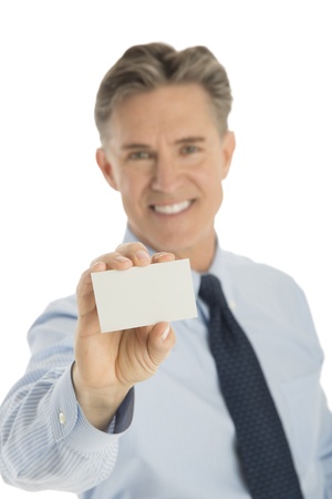 Portrait of confident mature businessman holding blank card against white backgroundの写真素材