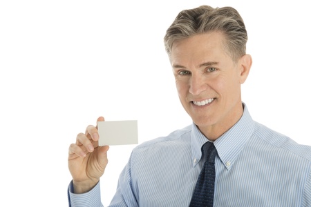 Portrait of happy mature businessman showing blank card against white backgroundの写真素材