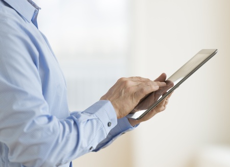 Midsection of businessman using digital tablet in officeの写真素材