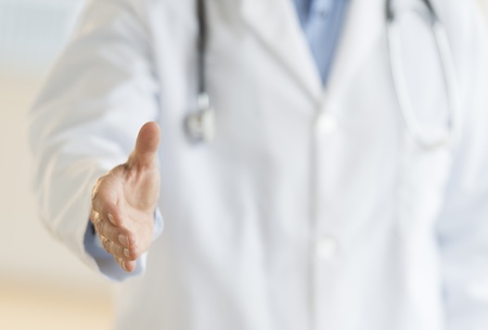 Midsection of male doctor extending his hand for a handshake in clinicの写真素材