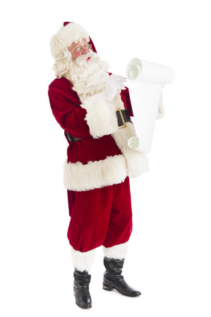 Full length of Santa Claus writing list while standing isolated over white backgroundの写真素材