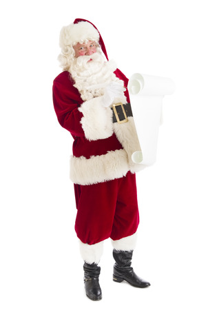 Portrait of Santa Claus preparing list while standing isolated over white backgroundの写真素材
