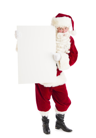 Portrait of Santa Claus pointing at blank billboard against white backgroundの写真素材