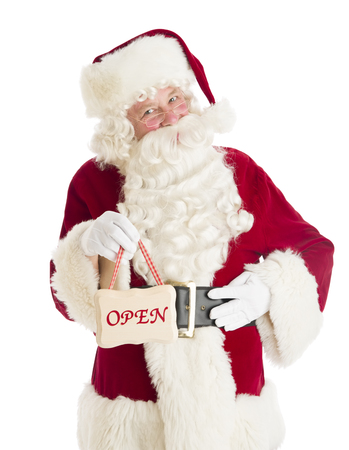 Portrait of Santa Claus holding Open sign while standing isolated over white backgroundの写真素材