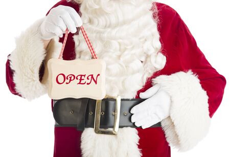 Midsection of Santa Claus holding Open sign while standing isolated over white backgroundの写真素材